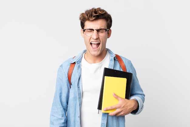 jonge knappe man die agressief schreeuwt en er erg boos uitziet. universitair studentenconcept