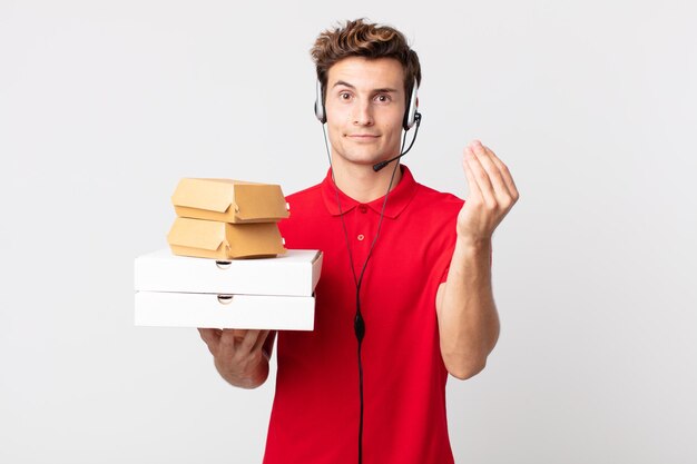 Jonge knappe man die capice of geldgebaar maakt en zegt dat je moet betalen. afhaal fastfood concept