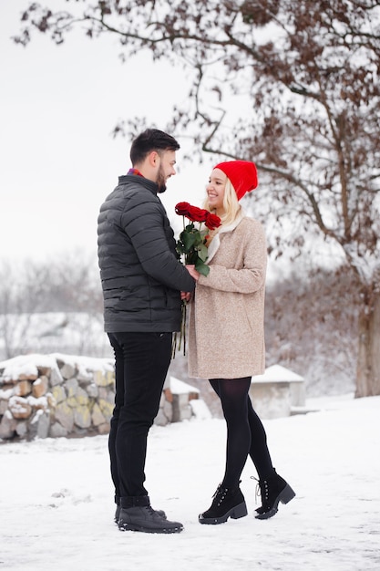 Jonge knappe man die een vrouw een boeket rozen geeft op Valentijnsdag