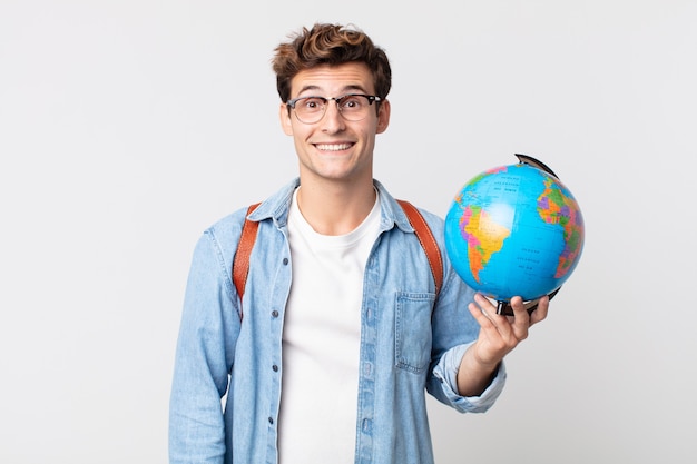 Jonge knappe man die er blij en aangenaam verrast uitziet. student met een wereldbolkaart