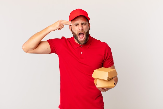 Jonge knappe man die er ongelukkig en gestrest uitziet, zelfmoordgebaar maakt een pistooltekenburger die concept levert