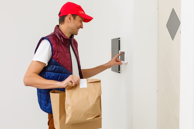 Jonge knappe man die eten bezorgt in een appartement