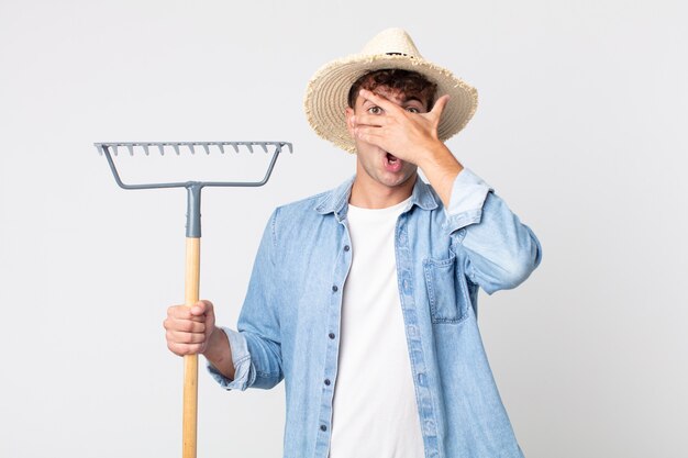 Jonge knappe man die geschokt, bang of doodsbang kijkt en zijn gezicht bedekt met de hand. boer concept