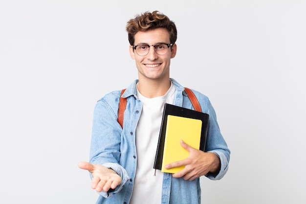 Jonge knappe man die vrolijk lacht met vriendelijk en een concept aanbiedt en toont. universitair studentenconcept