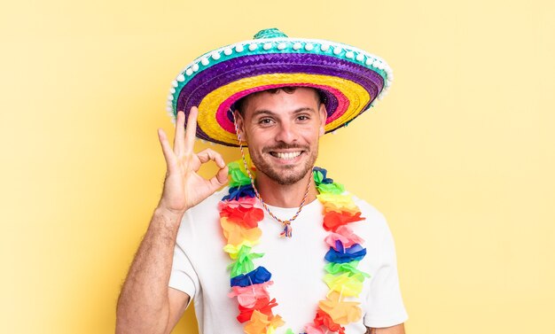 Jonge knappe man die zich gelukkig voelt, goedkeuring toont met een goed gebaar. Mexicaans feestconcept