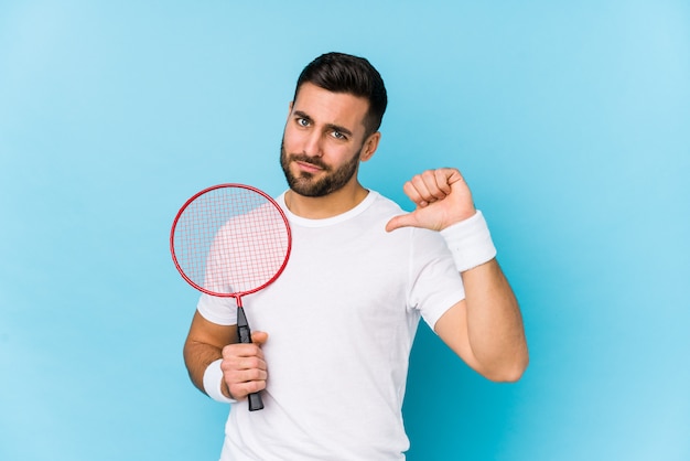 Jonge knappe man geïsoleerd badminton voelt zich trots en zelfverzekerd, voorbeeld te volgen.