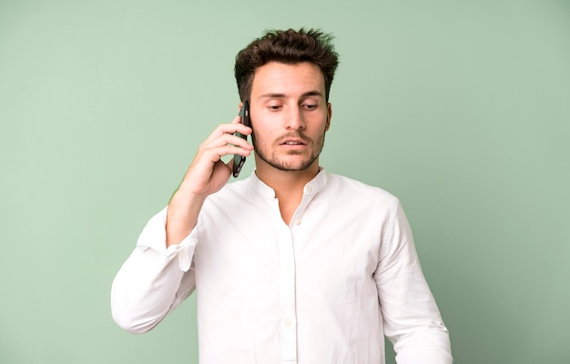 Jonge knappe man geïsoleerd met behulp van zijn telefoon