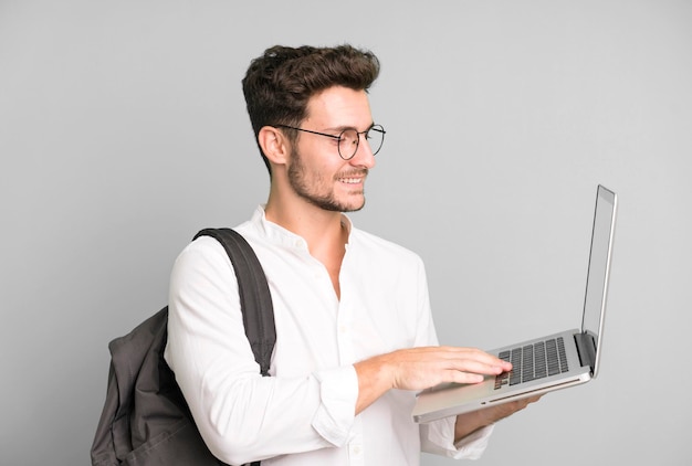 Jonge knappe man geïsoleerd met een laptop universiteitsstudent concept