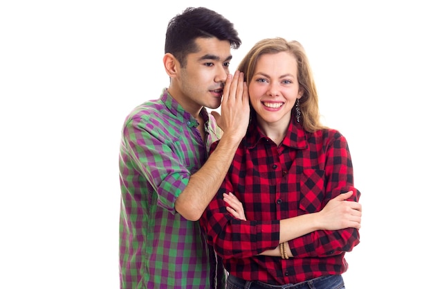 Jonge knappe man in gesprek met jonge verraste vrouw met lang kastanjebruin haar in geruit hemd