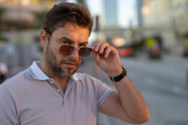 Jonge knappe man in klassieke polot-shirt op straat knappe zelfverzekerde stijlvolle hipster model pos