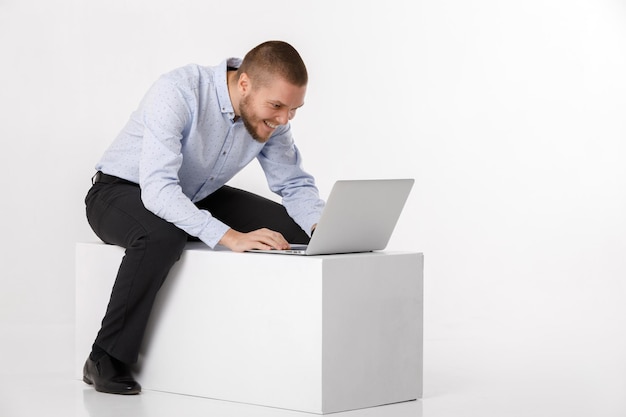 Jonge knappe man in overhemd en stropdas met behulp van laptop