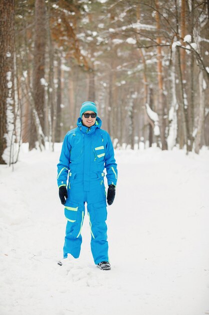 Jonge, knappe man in zonnebril glimlachend in de winter buiten