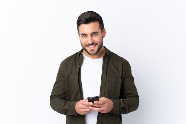 Jonge knappe man met baard geïsoleerd, een bericht verzenden met de mobiel