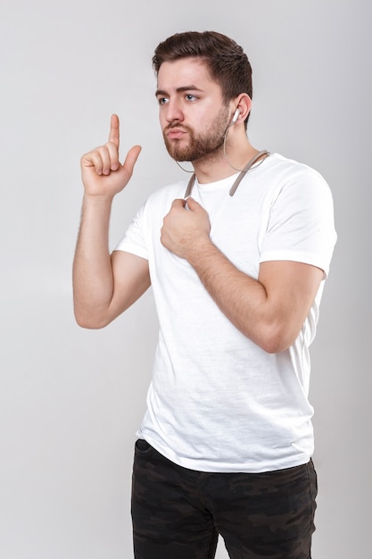 Jonge knappe man met baard in tshirt luisteren naar muziek op koptelefoon