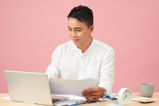 Jonge knappe man met behulp van laptop in zijn officeAsian