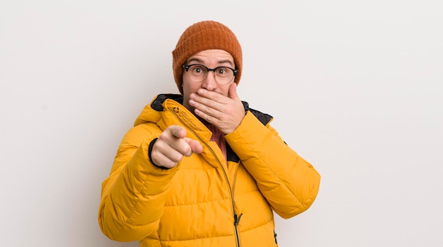 Foto jonge knappe man met een jas tegen de witte muur