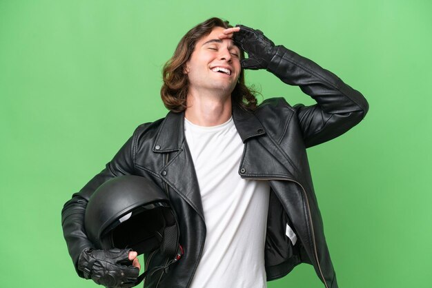 Jonge knappe man met een motorhelm geïsoleerd op groene chroma achtergrond lacht veel