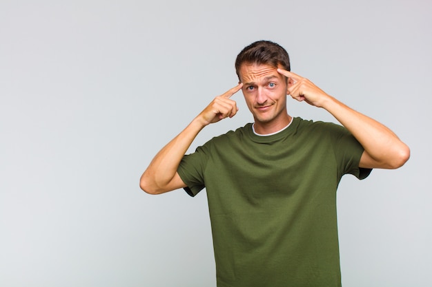 Jonge knappe man met een serieuze en geconcentreerde blik, die brainstormt en nadenkt over een uitdagend probleem