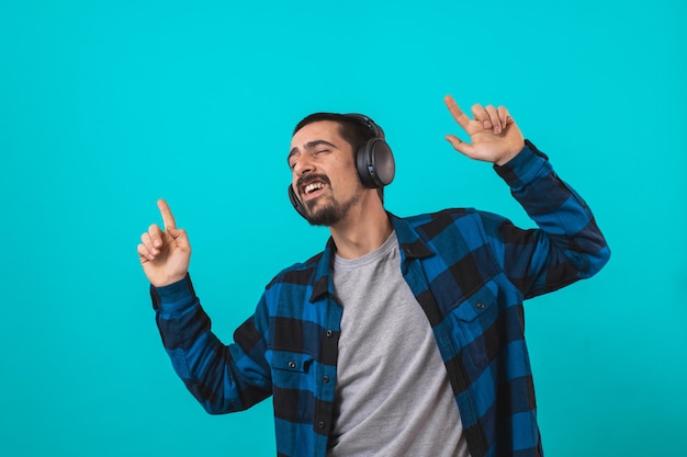 Jonge knappe man met gamer hoofdtelefoon set geïsoleerd op blauwe achtergrond
