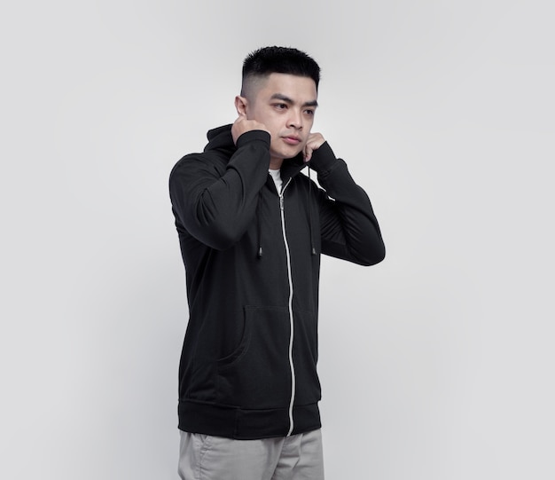 Jonge knappe man met zwarte hoodie rits geïsoleerd op de muur