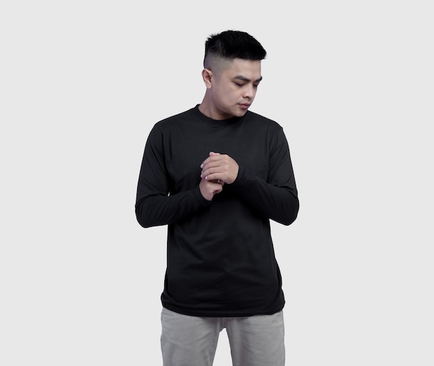 Jonge knappe man met zwarte t-shirt met lange mouwen geïsoleerd op wit