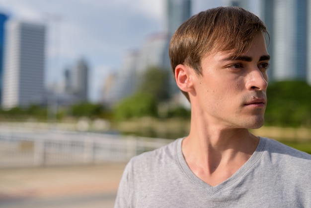 Jonge knappe man ontspannen in het park