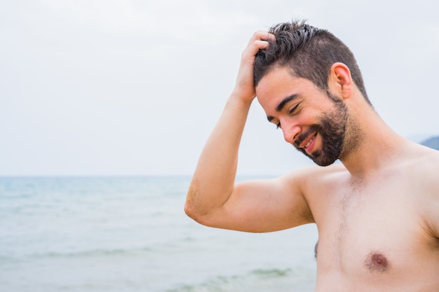 Jonge knappe man ontspannen op het strand