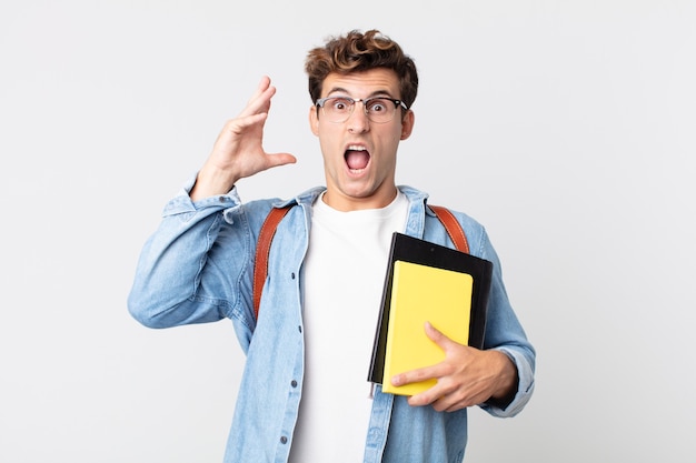 jonge knappe man schreeuwen met handen omhoog in de lucht. universitair studentenconcept