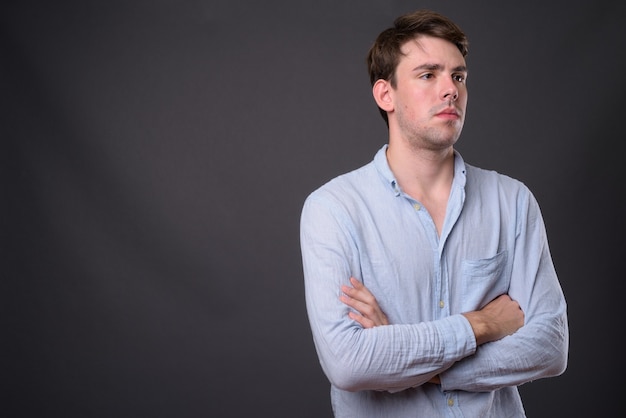 jonge knappe man tegen grijze muur