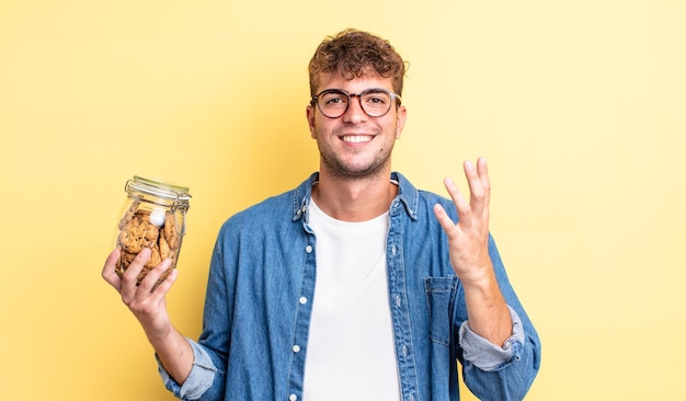 Jonge knappe man voelt zich gelukkig, verrast en realiseert een oplossing of idee. koekjes fles concept