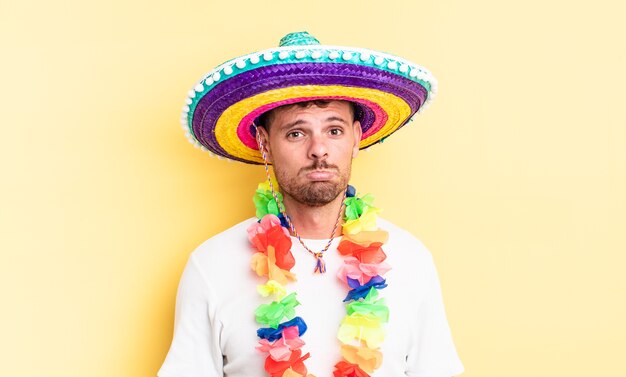 Jonge knappe man voelt zich verdrietig en zeurt met een ongelukkige blik en huilt. mexicaans feestconcept