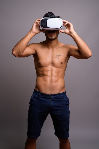 Jonge knappe Perzische man shirtless met behulp van virtual reality headset