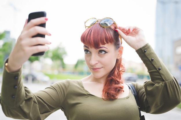 jonge knappe redhead vrouw die selfie neemt