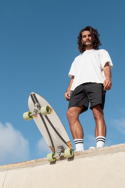 Jonge knappe skater die bovenaan de skatehelling staat