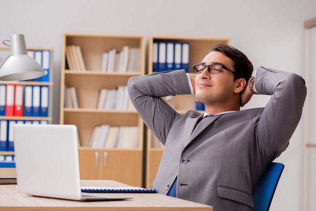 Jonge knappe zakenman die aan bureau werkt