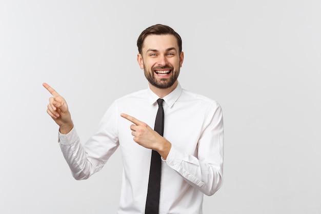 Jonge knappe zakenman die aan iets richt dat een vinger gebruikt.