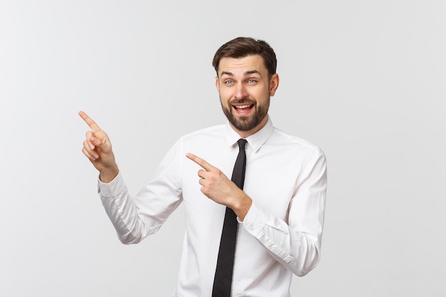 Jonge knappe zakenman die aan iets richt dat een vinger gebruikt.