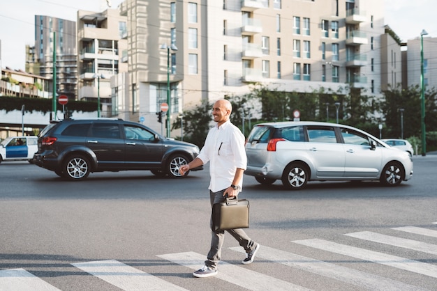 Jonge knappe zakenman die de straat kruist