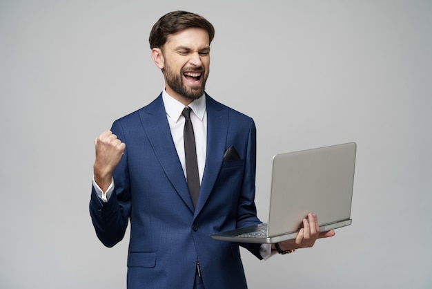 Jonge knappe zakenman die een laptop Computer met het Lege Scherm houdt