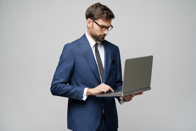 Jonge knappe zakenman die een laptop Computer met het Lege Scherm houdt