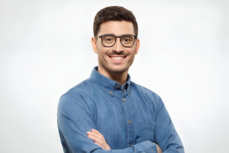 Foto jonge knappe zakenman met een blauw shirt en een bril met de armen gekruist glimlachend en zelfverzekerd.