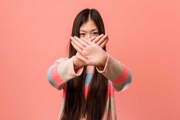 Jonge koele Chinese vrouw die een ontkenningsgebaar doet