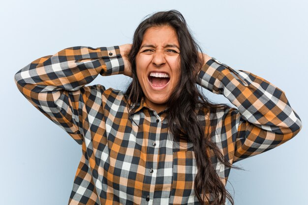 Jonge koele Indiase vrouw die betrekking hebben op oren met de handen proberen niet te hard geluid te horen.