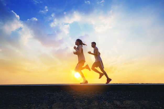 Jonge koppels sprinten op de weg Fit runner fitness loper tijdens outdoor training met zonsondergang