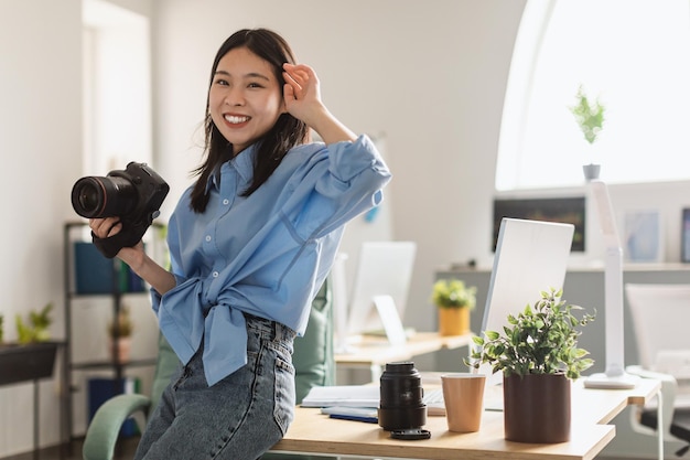 Jonge Koreaanse vrouwelijke fotograaf met fotocamera die thuis staat