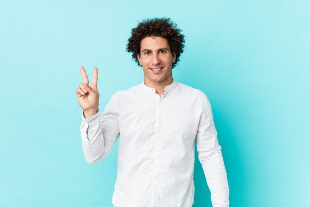 Jonge krullende volwassen man met een elegant shirt