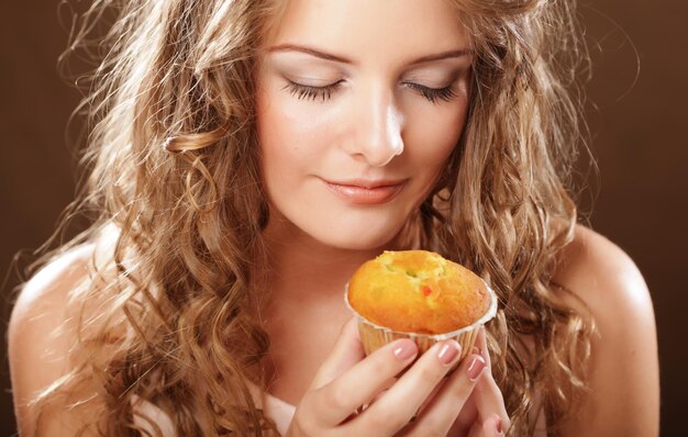 Jonge krullende vrouw met een cake