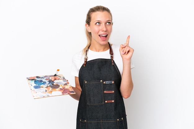 Jonge kunstenaar blanke vrouw met een palet geïsoleerd op een witte achtergrond denken een idee met de vinger omhoog