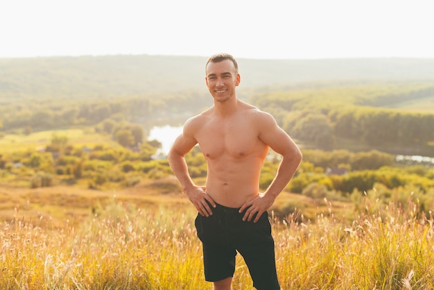 Foto jonge lachende man poseert na een training die buiten is gemaakt.