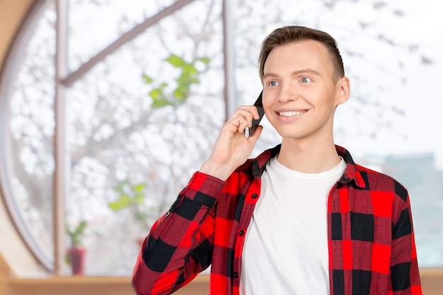 Jonge lachende man praten op de mobiele telefoon